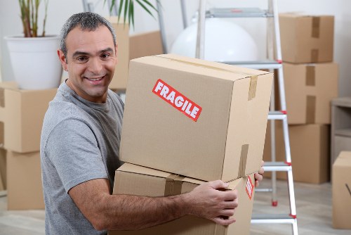 Removal team working in a Brompton residential street with packed boxes and a moving van