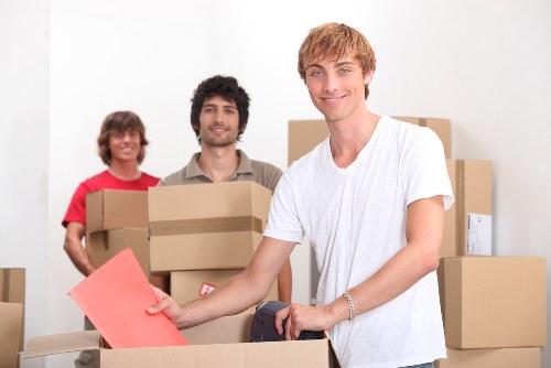 Professional movers carrying furniture through a Brompton street